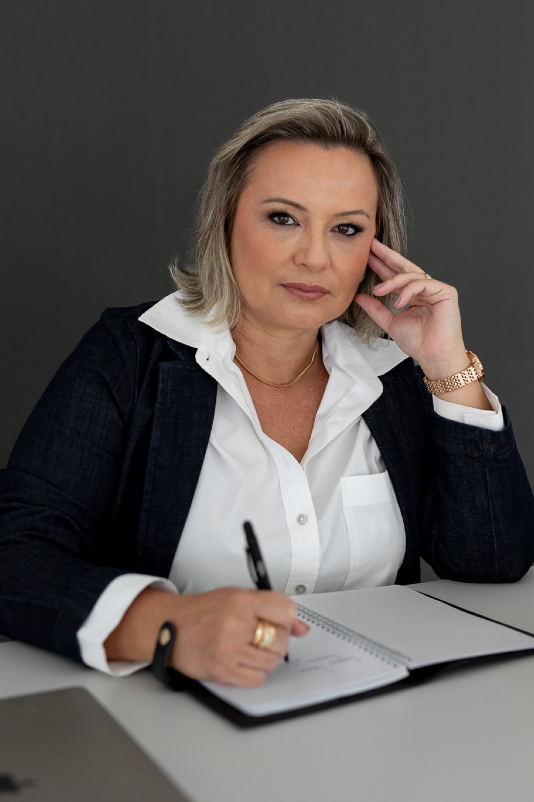 Fabiana Carvalho, fundadora da Valense, na mesa de trabalho escrevendo em um caderno, como nas sessões da mentoria